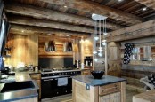 a light-colored chalet kitchen with wooden beams, stone countertops, built-in lights and pendant lamps