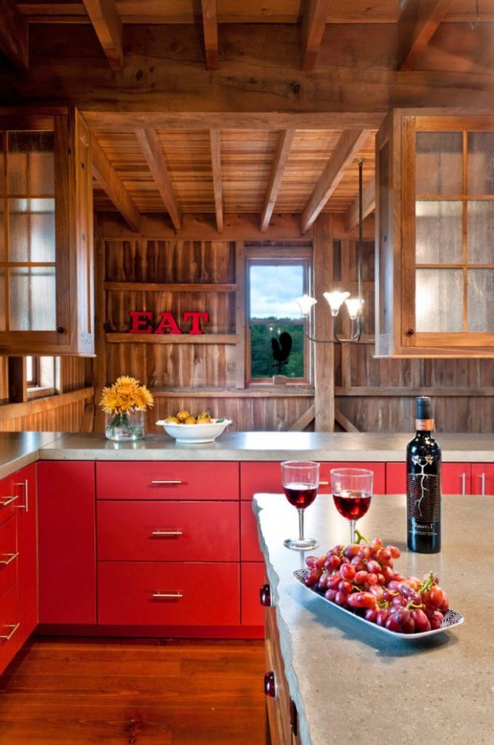 a creative and bright chalet kitchen clad with wood, with wooden beams, bright red cabinets and stone countertops looks bold and very cool