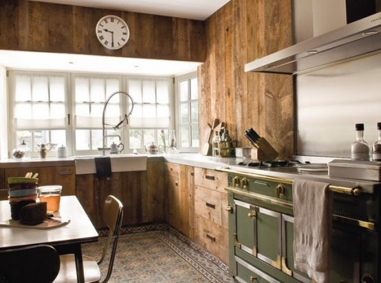 a chalet kitchen clad with reclaimed wood, with a tile floor, a green cooker, touches of metal here and there