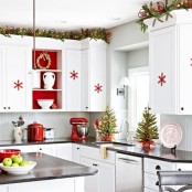 evergreen and light garlands, red snowflakes, red pots and mini Christmas trees in red wraps