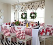 evergreen wreaths with pink bows, red and white linens and gift boxes make the kitchen feel like holidays