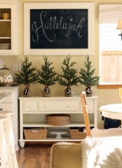 mini Christmas trees wrapped in burlap with numbers for Christmas decor in the kitchen