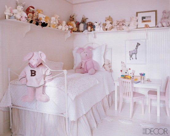 a neutral and light pink girl's room with a small metal bed with neutral bedding, a play dining set, an open long shelf with all the toys stored and displayed
