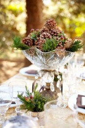 a crystal bowl and evergreens plus pinecones and berries for a vintage and rustic touch