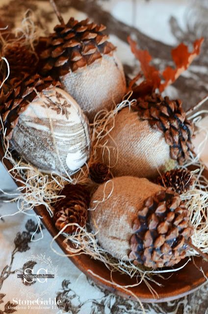 a whimsy wedding centerpiece of a wooden bowl with hay and pinecones made of burlap and usual pinecone parts