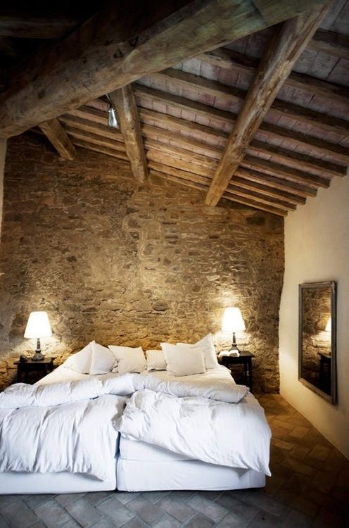A delicate bedding set is really necessary when it surrounded by raw stone and wood surfaces.