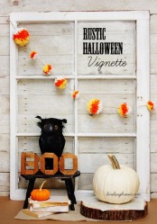 rustic Halloween styling with a window frame, a bold pompom garland, a white pumpkin, an owl and some letters