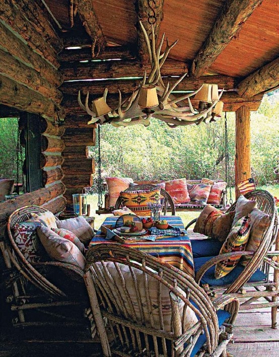 a rustic meets boho patio with rattan and wooden furniture, colorful textiles and an antler chandelier 