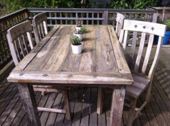 a simple rustic dining space wirh a wooden dining set and some potted plants
