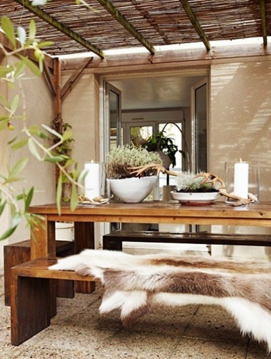 a rustic meets contemporary space with a wooden dining set, a roof and greenery