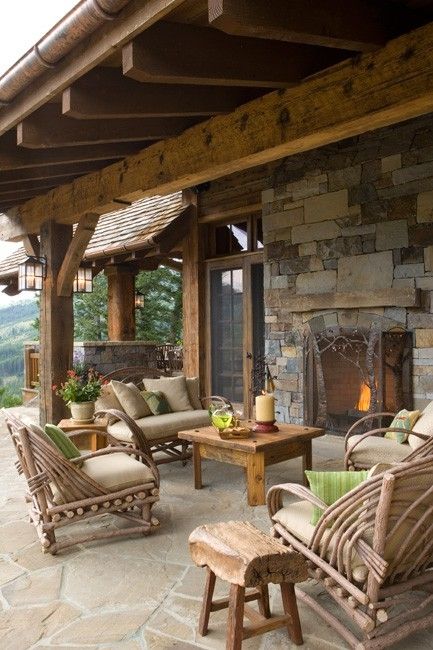 a rustic patio with rattan and wooden furniture, with a stone fireplace and touches of bright green