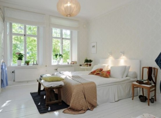 an airy Scandinavian bedroom with all things white, a pendant lamp and colorful textiles