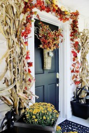 corn husks, bold fall leaves, berries and faux pumpkins, bold fall blooms in baskets and a faux fruit and veggie arrangement in a basket