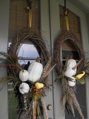 vine wreaths of white pumpkins, berries, foliage and feathers will make your front door feel more fall-like and Thanksgiving-like