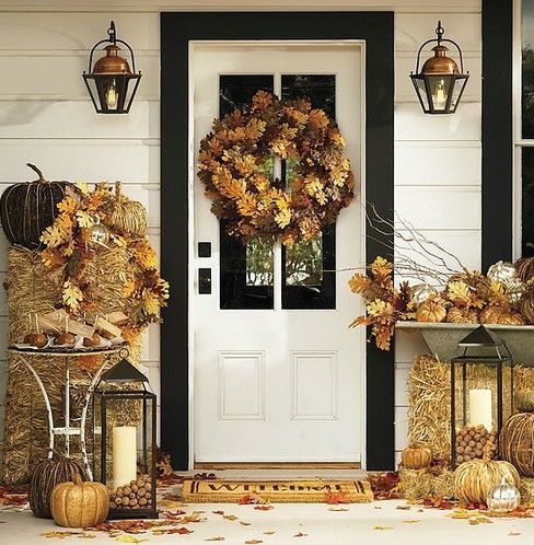 gold hay, leaves, pumpkins, candle lanterns with acorns, vine pumpkins make the front door sunny and cozy
