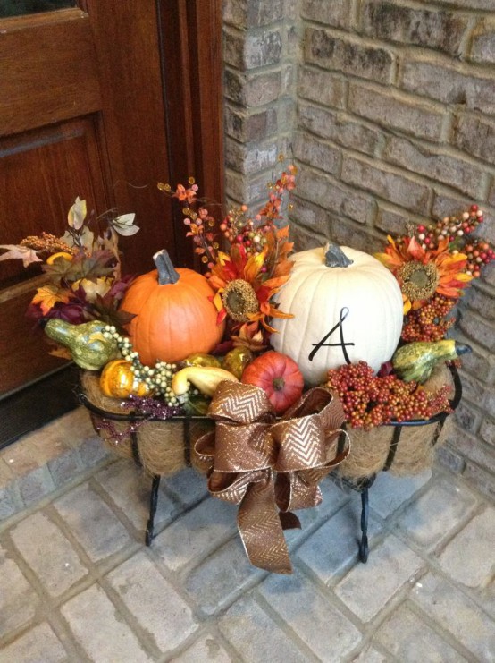 Combine traditional autumn decorations like pumpkins, colorful fall leaves, twigs with berries, and a little burlap to create a pleasing outdoor Thanksgiving arrangement. 
