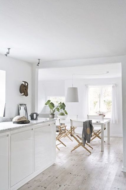 a white Nordic space with a whitewashed floor that adds a touch of warmth to the space