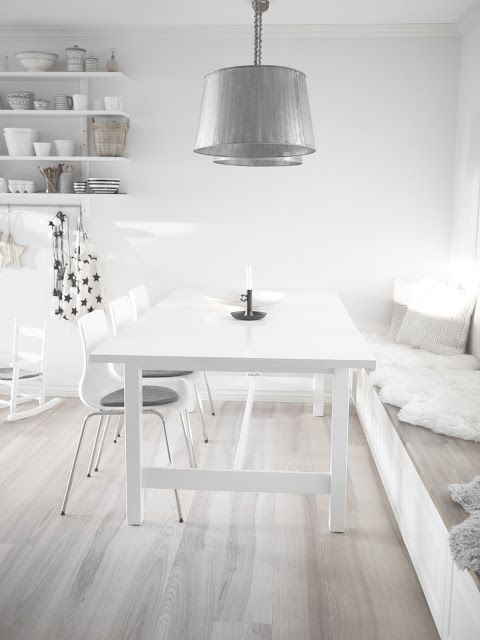 An all white room with a whitewashed floor and metallic touches is airy, light filled and very fresh