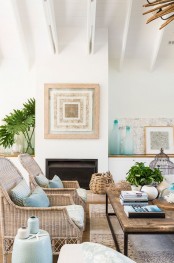 an ocean or coastal living room with a built-in fireplace, a wooden coffee table, wicker chairs, a basket for storage and some light blue and aqua touches for decor