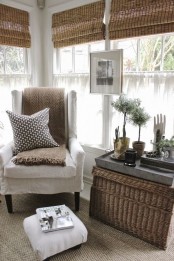 a wicker chest for storage and as a coffee table, woven blinds and a jute rug give a textural touch to this neutral space and make it eye-catchy