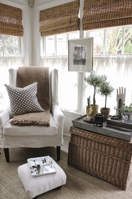 A wicker chest for storage and as a coffee table, woven blinds and a jute rug give a textural touch to this neutral space and make it eye catchy