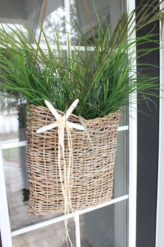 A wicker basket with greenery and a starfish is a lovely decoration for a beach or coastal space, use it instead of a usual wreath on your door