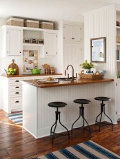a white farmhouse kitchen with rich stained countertops that contrast the space and make it bold and cozy