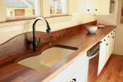 rich stained butcherblock countertops and matching floors add warmth and coziness to the kitchen
