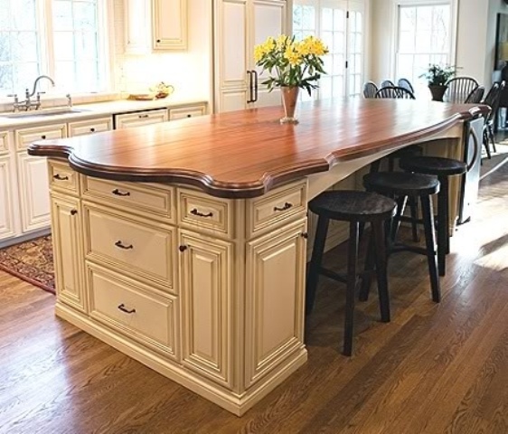 A neutral vintage kitchen island with a dark stained wooden countertop for elegance and chic in the space