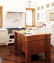 a vintage wooden kitchen island with matching coutnertops is a bold contrasting furniture piece to enliven a white kitchen