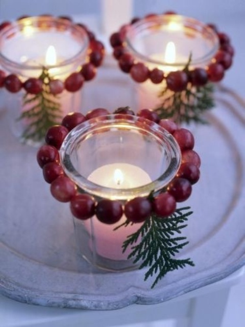 glass candleholders decorated with cranberries and evergreens are amazing Christmas decorations to rock, they look chic and nice