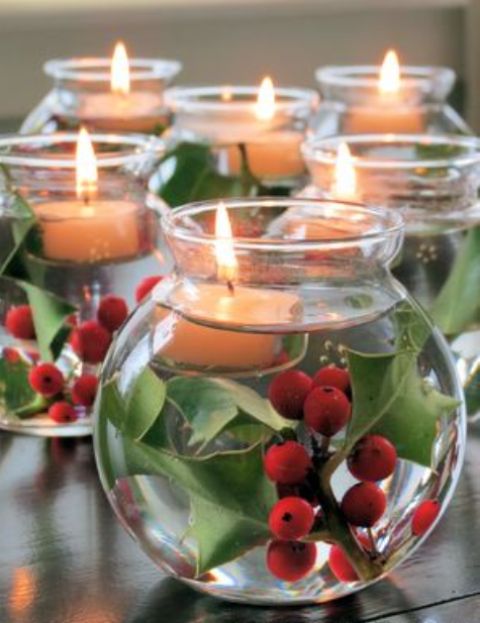 large round jars with greenery, berries and floating candles are very easy and super cute centerpieces for Christmas