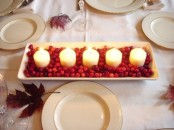 a very simple and casual Christmas centerpiece of a tray with cranberries and several pillar candles is a lovely and bold decor idea to rock