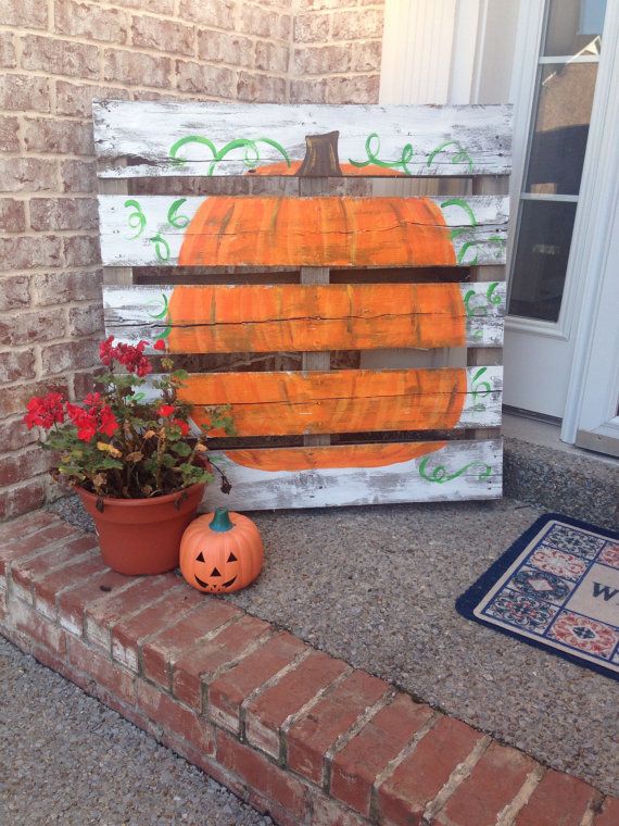 A fall pumpkin sign, a potted flower and a Jack o lantern for decorating your front porch