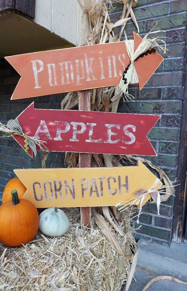 A whole bunch of fall signs in yellow, burgundy and orange, pumpkins and hay as a base