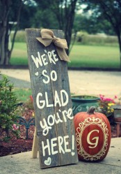 a reclaimed wood sign with a burlap bow and a painted pumpkin for a rustic fall touch to the space
