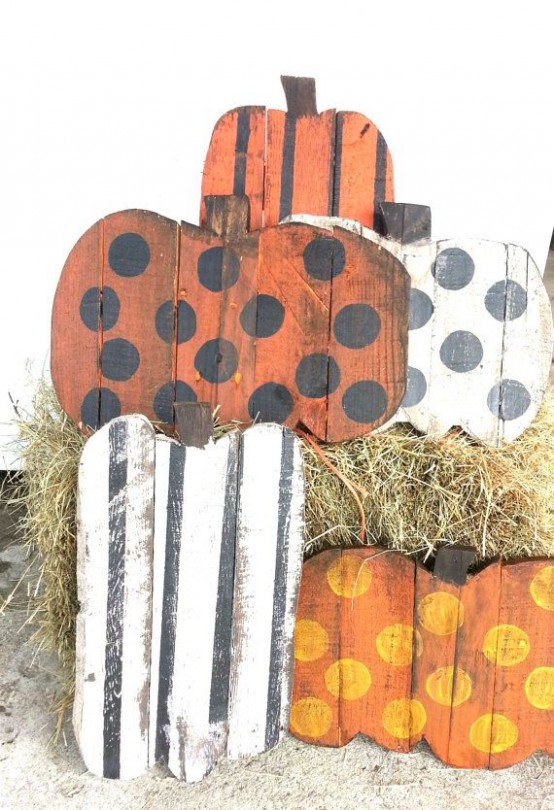 several colorful fall pumpkin signs with various shades and prints and hay for a rustic fall look