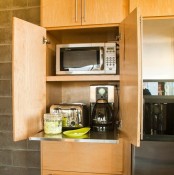 a light stained plywood cabient with several appliances and a retractable shelf is a very comfy idea to make your kitchen look neat