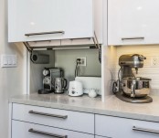 a white cabinet with a coffee machine, a kettle, a toaster and some other appliances is a cool idea to store your stuff without cluttering the space