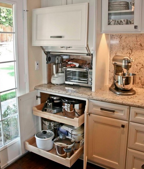 a small cabinet with several appliances and a lower cabinet with retractable shelves with pots and appliances for a functional kitchen