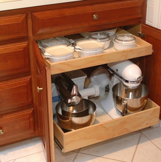 a rich stained lower cabinet with retractable shelves that hold appliances, pots and bowls is a cool idea to declutter the space