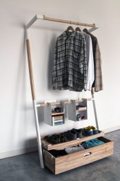 a small and smartly organized open closet with a drawer for clothes, some clothes hangers and soem suspended open boxes for accessories