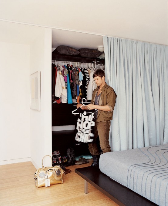 a closet with lots of shelves and a holder for clothes hangers can be hidden with a curtain and it declutters your space and doesn't make you make a separate closet room