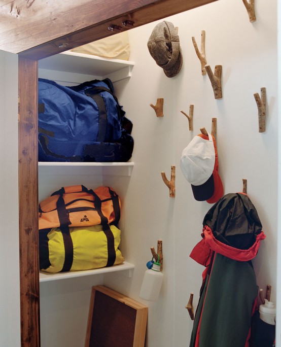 a closet with hooks on the wall that let hanging clothes, bags and other stuff and not to take any shelf and floor space for that