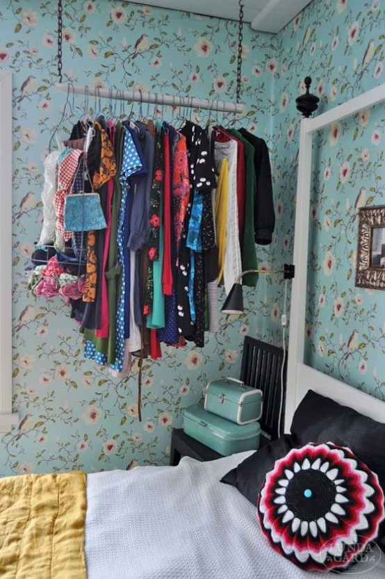 a chain and wood stick closet with clothes hangers is a non-bulky and airy idea that makes clothes part of decor