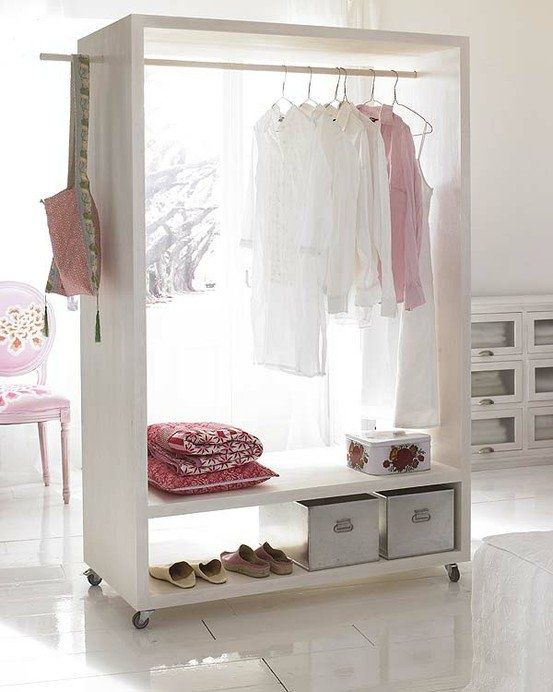 an open closet on casters features boxes, clothes hangers and can be moved anywhere you want it