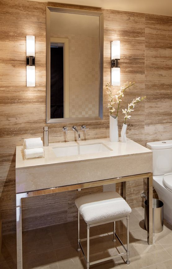 small and elegant wall lamps accent the mirror and make using it more comfortable at the same time