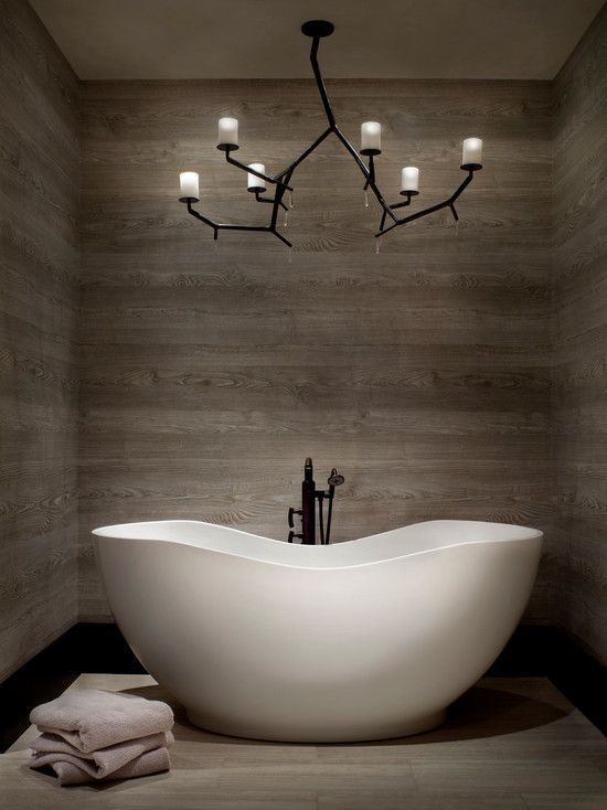 A statement chandelier in black with candle like lights is a stylish idea to accent a modern bathroom