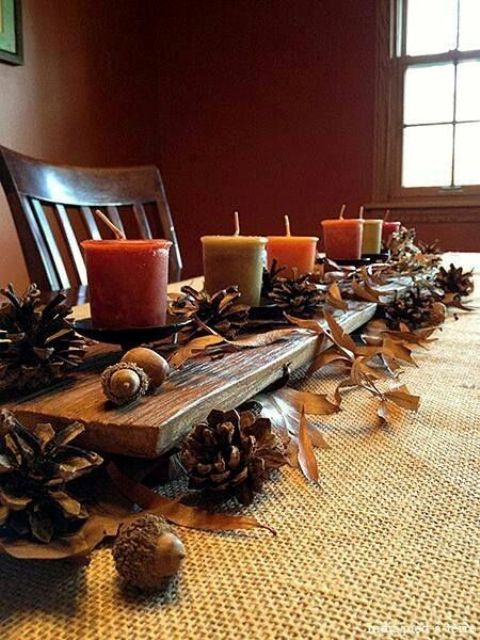 A fall centerpiece of pinecones, fall leaves, nuts and acorns and fall colored candles is a very natural autumn decoration