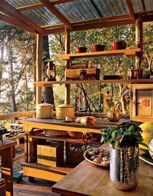 A small outdoor kitchen with wooden cabinets and open shelving to enjoy the views, touches of yellow and candle lanterns